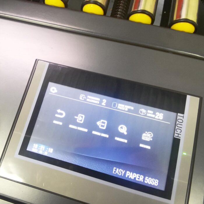 Zbliżenie panelu sterowania z ekranem dotykowym na Półautomatyczna zaklejarka Random Paper 50 SB, pokazująca ikony operacyjne pod etykietą EASY PAPER 50SB z żółtymi rolkami widocznymi nad wyświetlaczem.