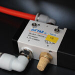 Zbliżenie zaworu pneumatycznego Airtac (3V310-C) na automatycznej formierce Speed Former 50 SB TN HM z czerwonymi i białymi rurkami. Etykieta pokazuje zakres 0,15-0,8 MPa i żółtą naklejkę "Y6" na urządzeniu.