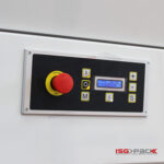 Zbliżenie na czarno-srebrny panel sterowania Tunel obkurczający S 85 DC, który posiada czerwony przycisk zatrzymania awaryjnego, żółte prostokątne przyciski, mały wyświetlacz cyfrowy i logo ISG PACK w rogu.