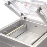 Zbliżenie przedstawia otwartą Przemysłową pakowarkę próżniową Easy Vac 500D FT z pustą komorą ze stali nierdzewnej, przezroczystą podnoszoną pokrywą i widocznymi wewnątrz listwami uszczelniającymi.