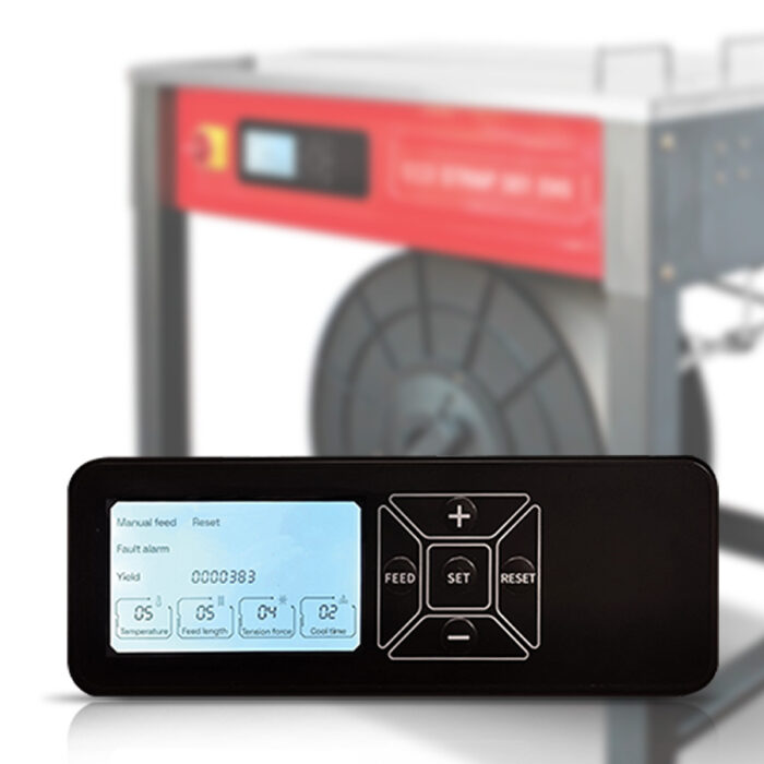 Zbliżenie elektronicznego panelu sterowania z wyświetlaczem i przyciskami, pokazującymi ustawienia i liczby, przed zamazaną Półautomatyczną bandownicą stołową Eco Strap 501 EVO z czerwoną etykietą i szpulą.