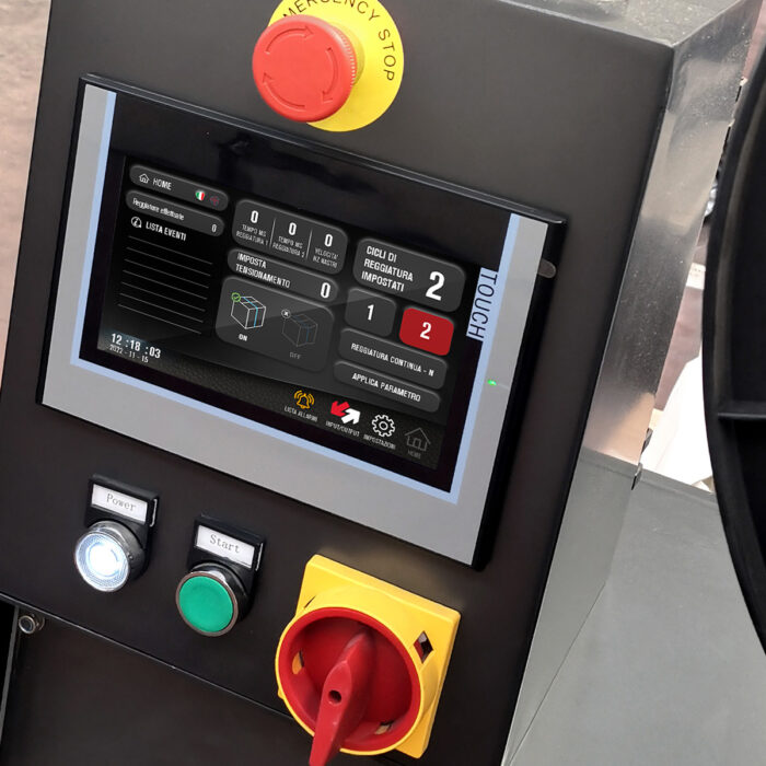 Panel sterowania dla Bandownica ramowa PP Speed Strap 509BL 512BL, wyposażony w ekran dotykowy z informacjami o maszynie, duży czerwony przycisk zatrzymania awaryjnego, zielone i czarne przyciski Start/Stop oraz żółte pokrętło na dole.