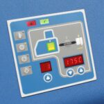 Zbliżenie Automatycznej zaklejarki Matic Tape 50 CF HM pokazuje niebieski panel sterowania z cyfrowymi wyświetlaczami wskazującymi 81 i 175°C, wieloma przyciskami oznaczonymi ikonami, schematem i białą ramką.