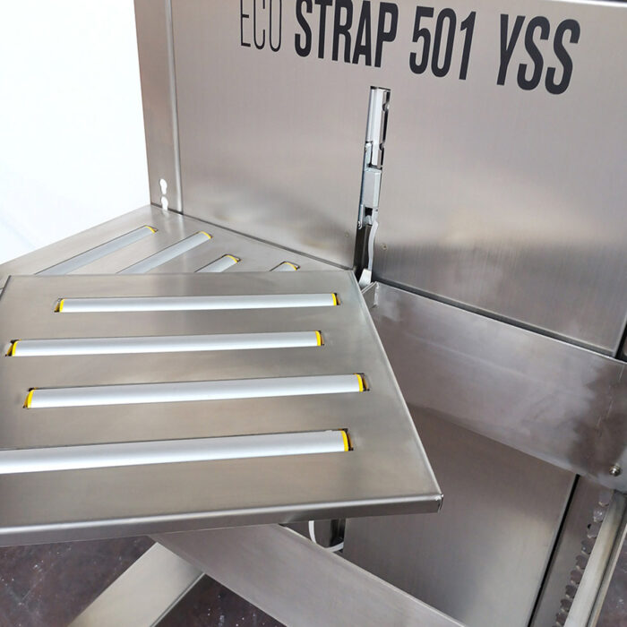 Zbliżenie na półautomatyczną bandownicę stołową Eco Strap 501 YSS, maszynę ze stali nierdzewnej z listwową platformą i pionowymi metalowymi częściami, zaprojektowaną do półautomatycznego wiązania lub pakowania.