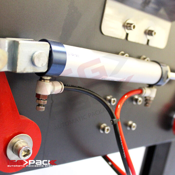 Zbliżenie metalowych prętów, złączy oraz czerwonych i czarnych kabli na maszynie przemysłowej. W lewym dolnym rogu widnieje logo SEPACK Automatic Packaging Systems oraz napis Półautomatyczna formierka Easy Form 50.