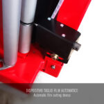 Zbliżenie automatycznego urządzenia do cięcia folii z metalowymi rolkami i czarnym mechanizmem, zamontowanego na czerwonej Półautomatyczna owijarka paletowa PRE-STRETCH Easy Wrap 2000 B. Tekst: DISPOSITIVO TAGLIO FILM AUTOMATICO / Automatyczne urządzenie do cięcia folii.