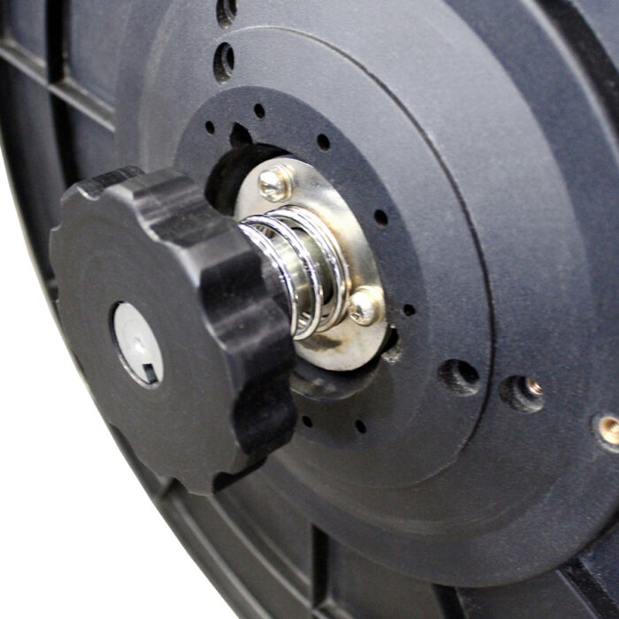 Zbliżenie elementu mechanicznego z Bandownica ramowa wiązarka PP Speed Strap 505R/509R/512R, pokazujące czarne plastikowe pokrętło, metalową sprężynę i okrągłe metalowe części, prawdopodobnie część szpuli lub mechanizmu kołowrotka.