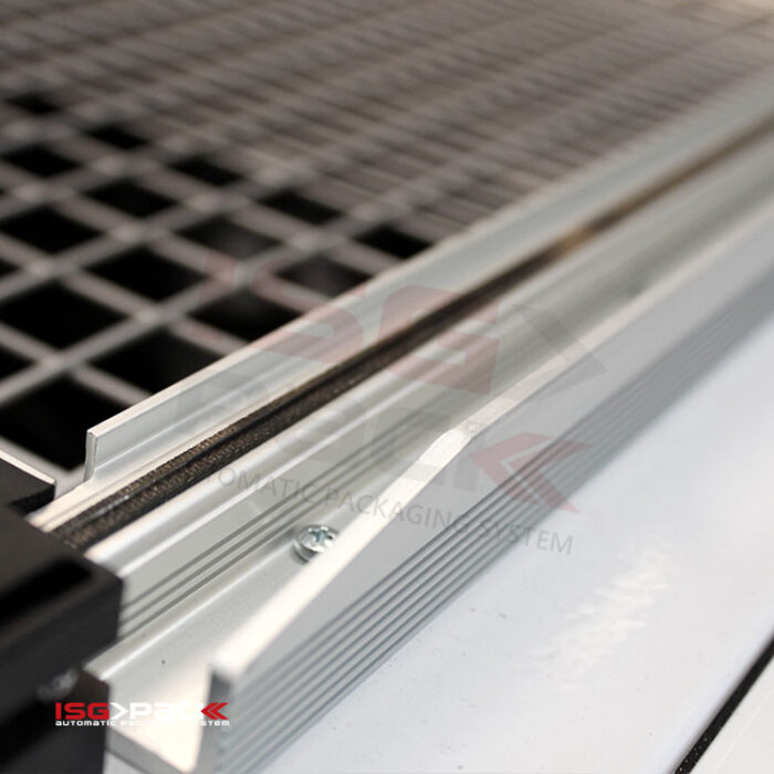 Zbliżenie na metalową kratkę przemysłową ze srebrną aluminiową ramą i rowkowaną krawędzią, z widocznym brandingiem, wykonaną z precyzją podobną do Zgrzewarki kloszowej do folii Easy Sealer 85.