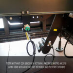 Zbliżenie na głowicę taśmującą w Automatycznej formierce Speed Former 50 SB XL, z czujnikami wykrywającymi zerwanie i obecność taśmy, wraz z widocznymi elementami elektronicznymi i czarnymi metalowymi elementami; włoskie i angielskie podpisy poniżej.