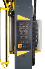 Zbliżenie panelu sterowania Półautomatyczna owijarka palet OneWrapArm z czarno-żółtą obudową, wieloma przyciskami i ikonami, widocznym czerwonym przyciskiem zatrzymania awaryjnego, niebieskimi i żółtymi przełącznikami, z częściami maszyny widocznymi w tle.